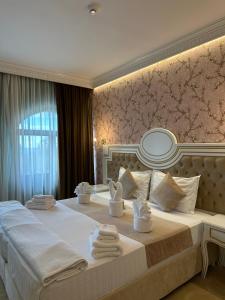 a bedroom with a large bed with towels on it at Cardinale Resort in Iaşi +144 photos