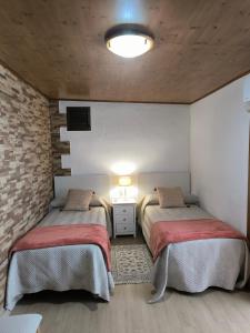 a bedroom with two beds and a brick wall at Casa Chemar in La Orotava