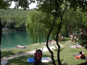 a group of people laying on the grass near a lake at Dimora Visconti in San Demetrio neʼ Vestini