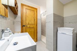 a bathroom with a sink and a wooden door at Maison Carrel Elegant 2 in Breuil-Cervinia +33 photos