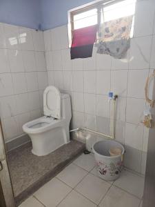 a bathroom with a toilet and a window at HACHIKOs HAVEN in Guwahati