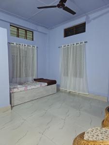a bedroom with two beds and a ceiling fan at HACHIKOs HAVEN in Guwahati