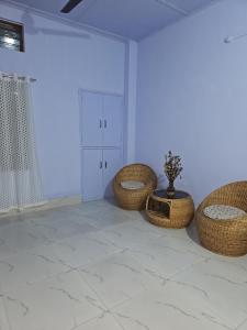 a room with three wicker chairs and a table at HACHIKOs HAVEN in Guwahati