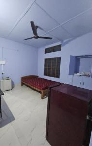 a living room with a couch and a ceiling fan at HACHIKOs HAVEN in Guwahati