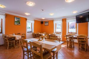 a dining room with tables and chairs and windows at Pension Török in Lesce