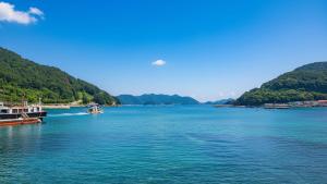 a view of a large body of water with mountains at Tongyoung Macaio Pension in Tongyeong +1 photo
