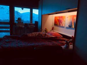 a bedroom with a bed and a large window at Residence i Larici in Prato Nevoso +48 photos