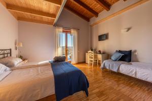 a bedroom with two beds and a desk and a window at Alloggi agrituristici Paraschos in San Floriano del Cóllio