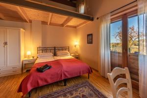 a bedroom with a large bed and a large window at Alloggi agrituristici Paraschos in San Floriano del Cóllio