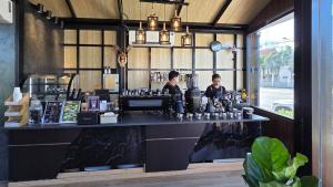 two people sitting at a counter in a coffee shop at Miramalin Resort Krabi in Ao Nang Beach