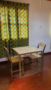 a wooden table and two chairs and a table and bench at Kabila moja hostel in Iringa +38 photos