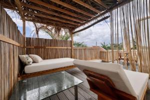 a porch with a couch and a glass table at Bazaar Square Lodges in Grand-Baie
