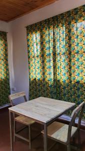 a table and chairs in front of a window at Kabila moja hostel in Iringa