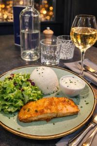 a plate with a fish and salad and a glass of wine at Les Chiens du Guet in Saint Malo +76 photos