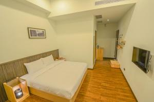a bedroom with a bed and a flat screen tv at 儷景民宿 in Magong