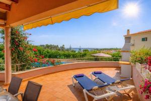 a patio with two lounge chairs and a pool at Villa Betonia in Punta Prima