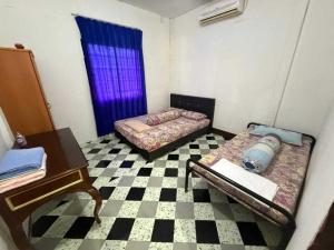 a room with two beds and a desk and a window at OYO 91270 Sabsa Homestay in Kuching