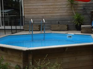 a swimming pool with two faucets in front of a house at Maison dans un écrin de verdure in Sorèze