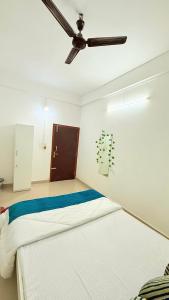 a bedroom with a bed and a ceiling fan at Serenyaa in Dibrugarh
