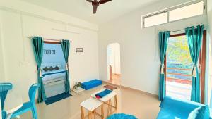 a living room with a blue couch and a window at Serenyaa in Dibrugarh