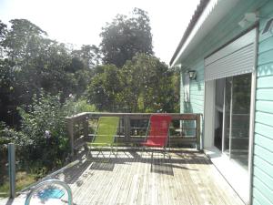 three chairs sitting on the deck of a house at Maison dans un écrin de verdure in Sorèze