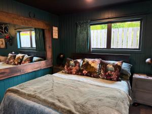 a bedroom with green walls and a bed with pillows at The Olde Whiskey Room in Queenstown