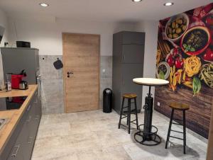 a kitchen with two bar stools and a painting on the wall at Ferienwohnung Forest Life in Hasselfelde