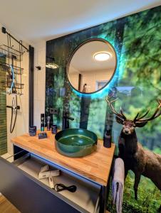 a bathroom with a sink and a deer on the wall at Ferienwohnung Forest Life in Hasselfelde +19 photos