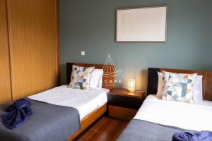 a bedroom with two beds and a picture on the wall at Vila Sol in Prazeres