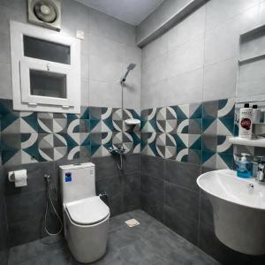 a bathroom with a toilet and a sink at Majd Lux Stay in Ma‘ābīlah