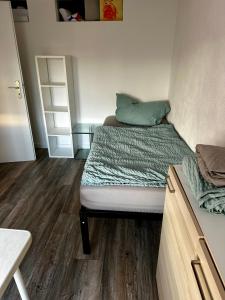 a small bedroom with a bed and wooden floors at Zollzeche Stadtwohnungen in Staßfurt