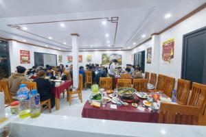 a group of people sitting at tables in a restaurant at À Lôi Homestay Đồng Văn in Dồng Văn