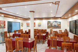 a restaurant with tables and chairs and paintings on the walls at À Lôi Homestay Đồng Văn in Dồng Văn