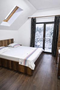 a bedroom with a bed and a large window at Poiana Cerbilor in Slatina
