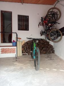 a bike is parked next to a wall with logs at Casa de los Abuelos in Cardeña