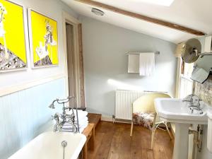 a bathroom with a sink and a tub and a mirror at The Artist's House in Norwich +10 photos