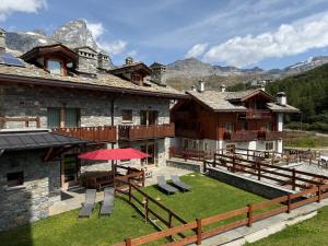 a building with a patio with a table and chairs at Maison Carrel Elegant 2 in Breuil-Cervinia