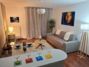 a living room with a couch and a table with wine glasses at Parenthèse lumineuse près de Disney, Parking privé in Montévrain