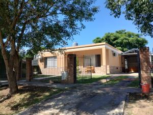 a house with a gate and a tree at JOAQUINA in Ramallo
