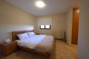 a bedroom with a bed with white sheets and a window at Chalets in Arez - Adagio in Al Arz