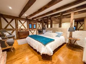 a bedroom with a large bed and a chair at LE CLOS DU BENESTAR in Mauvezin-dʼArmagnac +17 photos