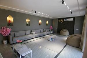 a living room with couches and tables and flowers at كهف الريف Reef Cave in Al Ḩamrāʼ