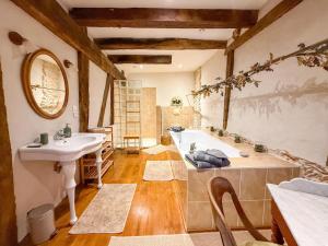 a bathroom with a bath tub and a sink at LE CLOS DU BENESTAR in Mauvezin-dʼArmagnac