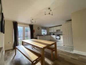 a living room with a wooden table and a kitchen at Spacious Bracknell Four Bedroom House in Bracknell