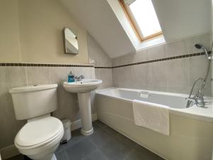 a bathroom with a toilet and a sink and a bath tub at Spacious Bracknell Four Bedroom House in Bracknell +15 photos