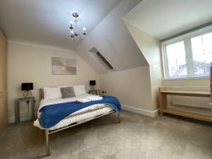 a bedroom with a bed with a blue blanket at Spacious Bracknell Four Bedroom House in Bracknell