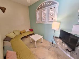 a living room with a couch and a tv at villa vue mer - piscine privée in Las Terrenas