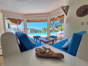 a living room with a table and chairs and a pool at villa vue mer - piscine privée in Las Terrenas