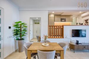 a dining room with a wooden table and chairs at 2BR Seafront Elegance with Balcony & Sea Views by 360 Estates in St. Paul's Bay