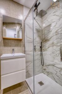 a bathroom with a shower and a sink at 2BR Seafront Elegance with Balcony & Sea Views by 360 Estates in St. Paul's Bay +42 photos